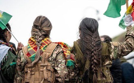 Syrian militiaman shows off what he claims to be severed Kurdish fighter's braid as Damascus asserts control